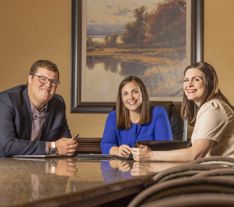 The Trust Company's Financial Planning team smiling from the board room table