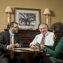 Two men and a woman in an estate settlement meeting in an office