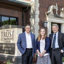 Michael Carlisle, Jennifer Mohney & Mike Davies standing in front of The Trust Company, Lawrence KS